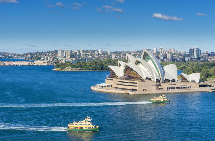Aerial view of Sydney Harbour with ferries and cruises passing by Sydney Opera House during the daytime