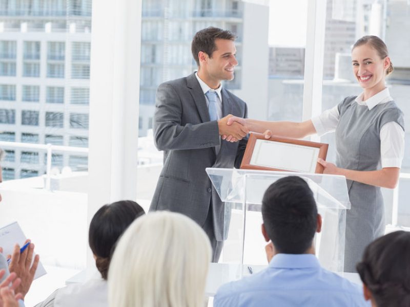 Business people receiving award in meeting room